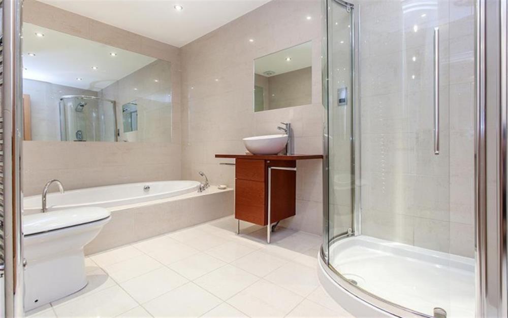 The family bathroom with oval sunken bath and separate shower at Genoa in Salcombe