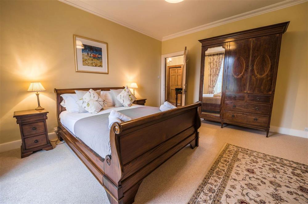 Bedroom five, with a mahogany 5’ king-size sleigh bed  at Gitcombe House, Dartmouth