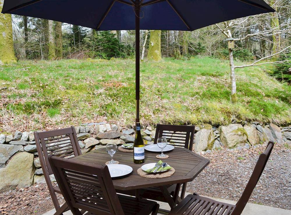 Sitting-out-area with funiture and woodland views at Glan Y Gors in Beddgelert, Gwynedd