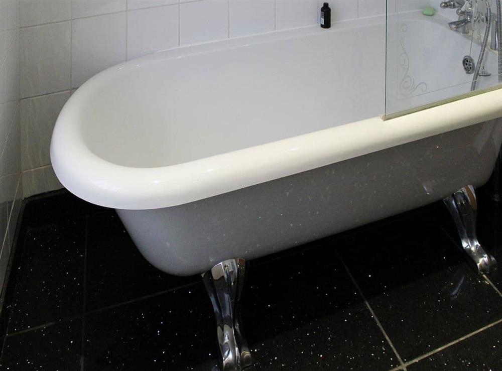 Bathroom with claw foot bath and shower attachment at Glaramara in Kendal, Cumbria, England