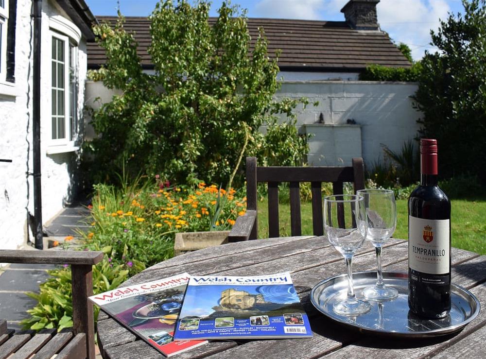 Lawned garden with paved patio area with garden furniture at Glasfor in Llansantffraed, near Aberaeron, Cardigan, Dyfed