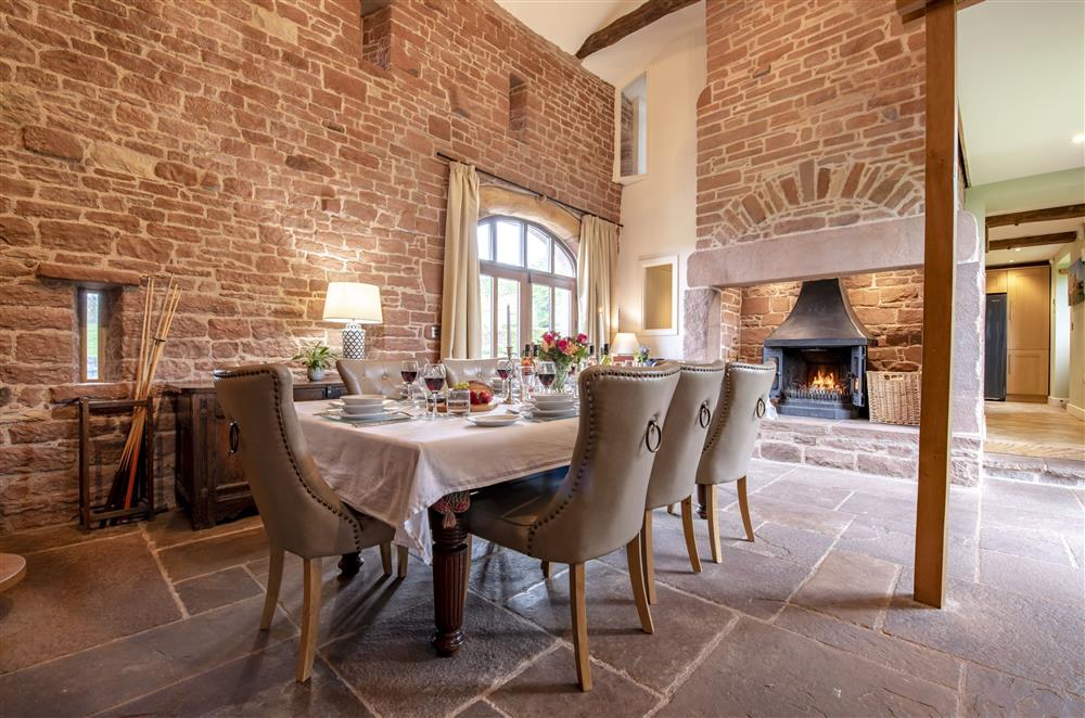 Dining room with table seating eight guests and wood burning stove at Glassonby Old Hall and Jennys Croft, Glassonby