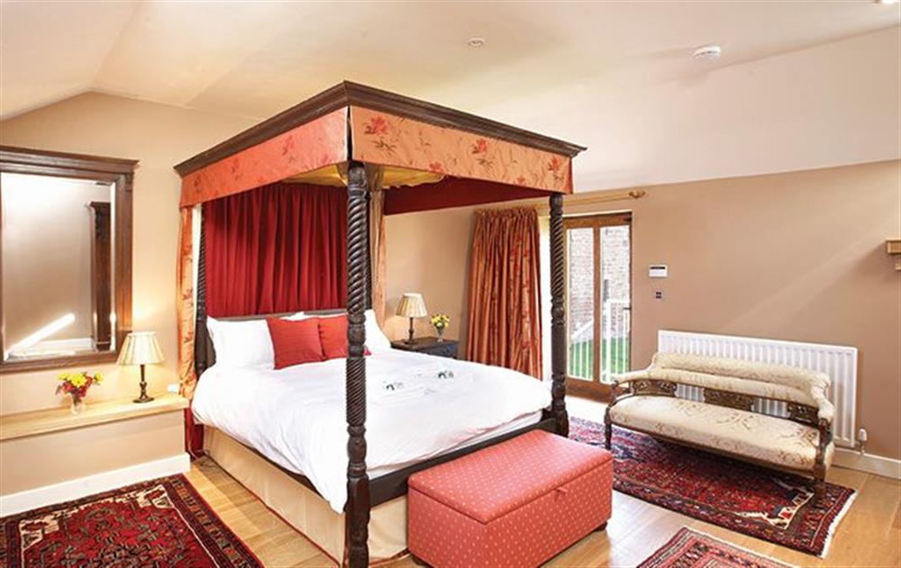 Master bedroom with 5’ four poster bed with en-suite bathroom and separate shower at Glassonby Old Hall, Glassonby