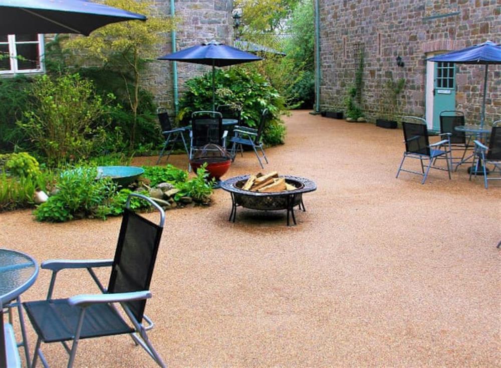Shared courtyard with garden furniture, barbecue, summerhouse and chiminea at The Granary, 