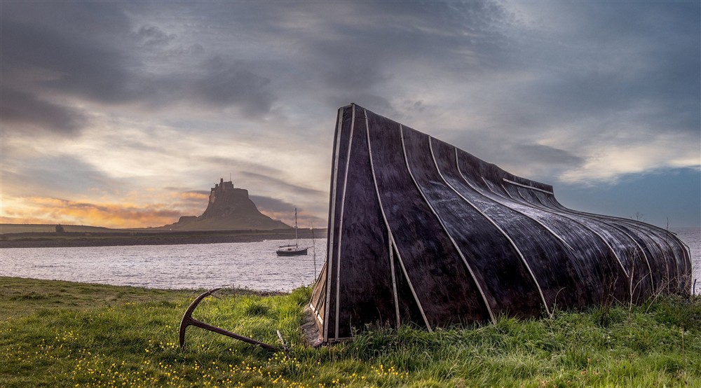 A boat shed on Holy Island with Lindisfarne Castle in the background, near Glen House, Northumberland at Glen House in Berwick-upon-tweed, Northumberland