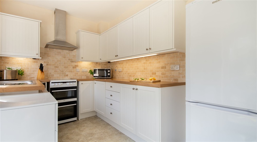 The U-shaped kitchen with cooker and hob, microwave, toaster and fridge freezer at Glen House in Berwick-upon-tweed, Northumberland