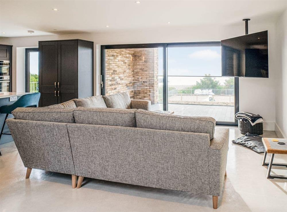 Open plan living room with sea views. Sliding door opens up onto the balcony at Glenvar in Elmer, West Sussex