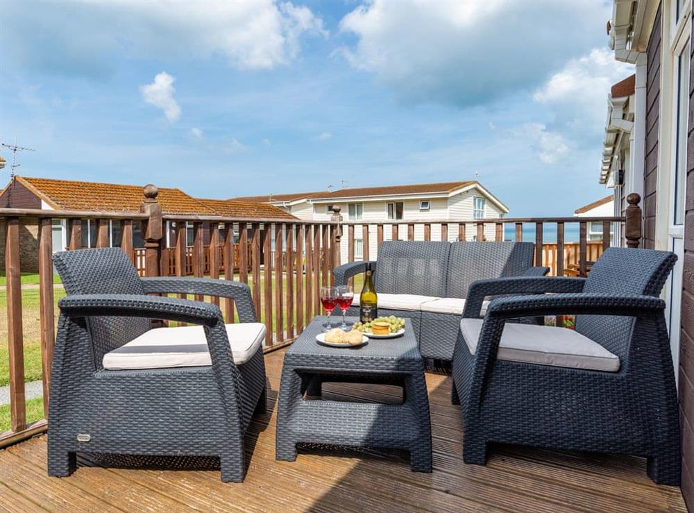 Enclosed decking with comfortable outdoor furniture at Beach Cottage 71, 