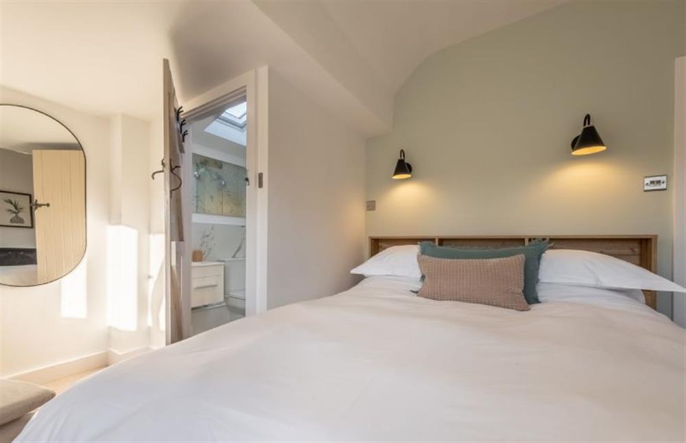 Master bedroom with door to en-suite shower at Golf Cottage, West Runton near Cromer