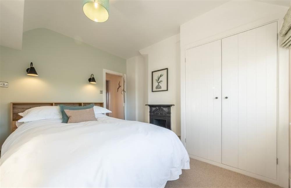 Master bedroom with ornamental fireplace at Golf Cottage, West Runton near Cromer