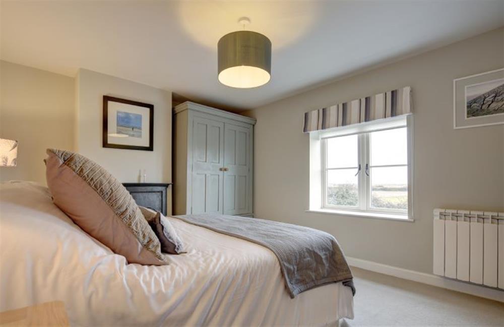 First floor: Master bedroom with views to the marshes at Goose Cottage, Titchwell near Kings Lynn