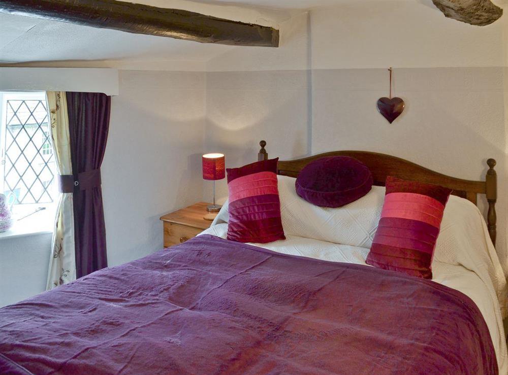 Comfortable double bedroom with exposed wooden beams at Goose Green Cottage in Baslow, near Bakewell, Derbyshire