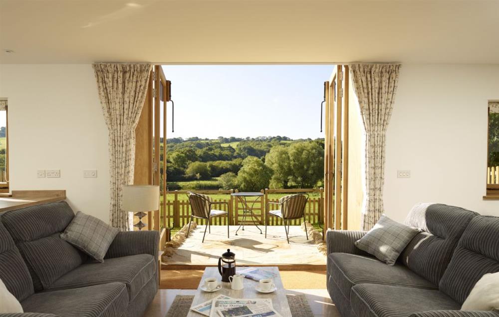 Sitting room with double doors leading out to the terrace at Goose Run Cottage, Corscombe