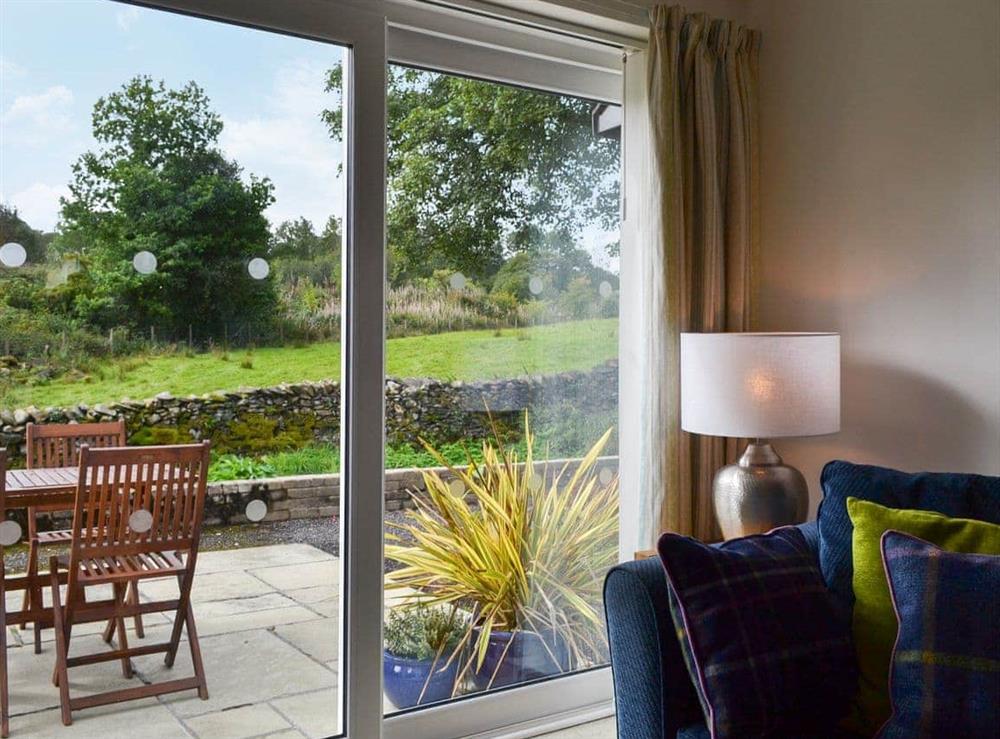 Large patio doors opening onto the rear riverside terrace at Gowan in Staveley, near Kendal, Cumbria