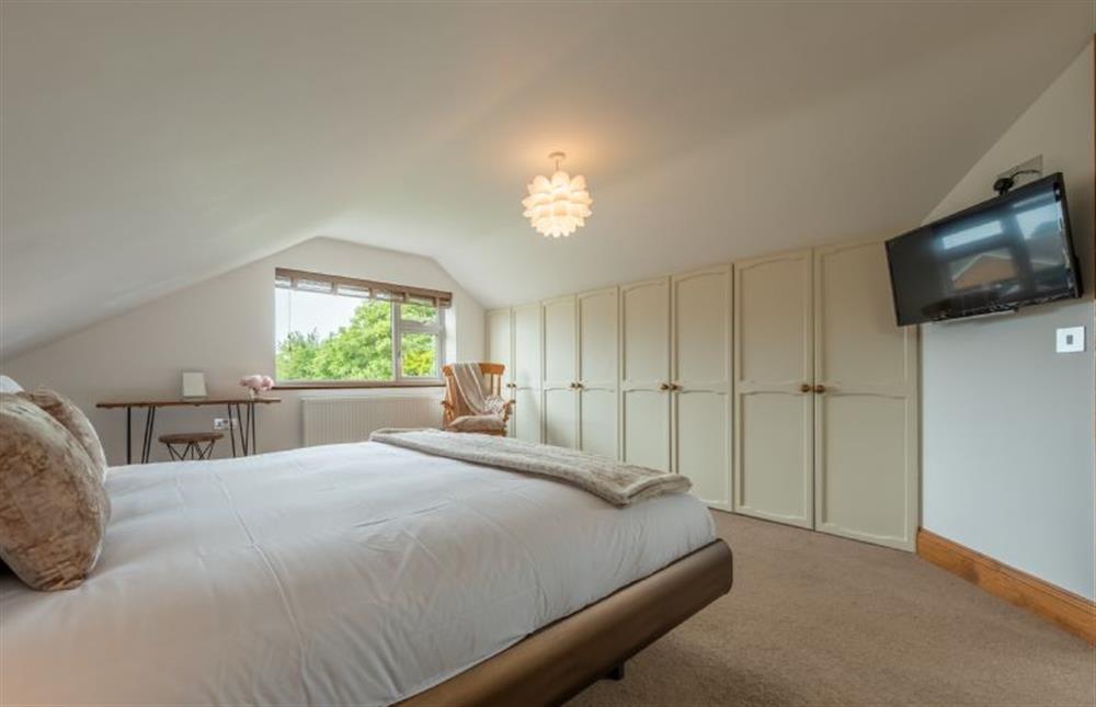 First floor: Master bedroom with super-king size bed and television at Grace Cottage, Heacham near Kings Lynn
