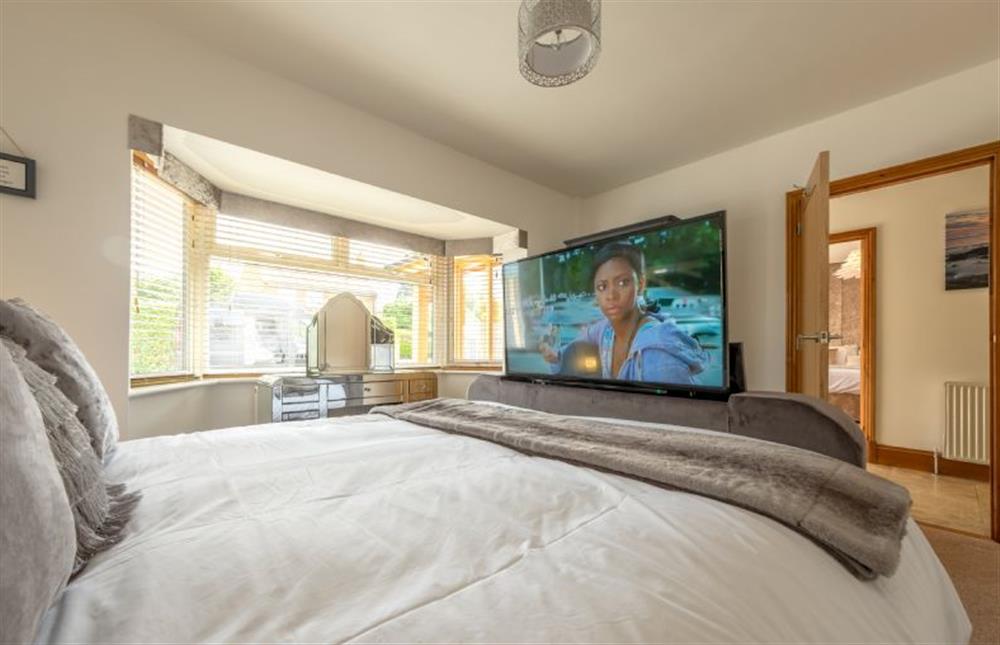 Ground floor: Bedroom two with pop up television in king-size bed at Grace Cottage, Heacham near Kings Lynn