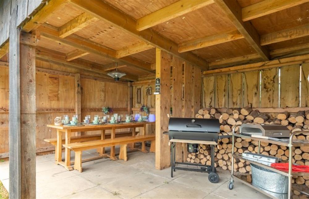 Outside: Dining area and BBQ with pizza oven at Grace Cottage, Heacham near Kings Lynn