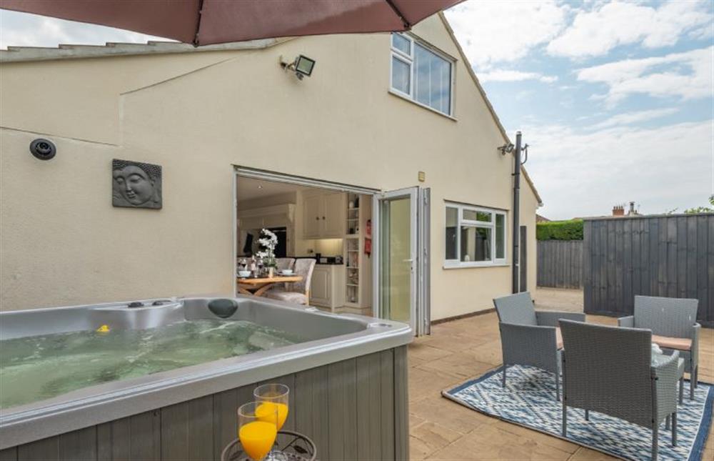 Outside:  Hot tub on the patio area with ample seating/dining space at Grace Cottage, Heacham near Kings Lynn