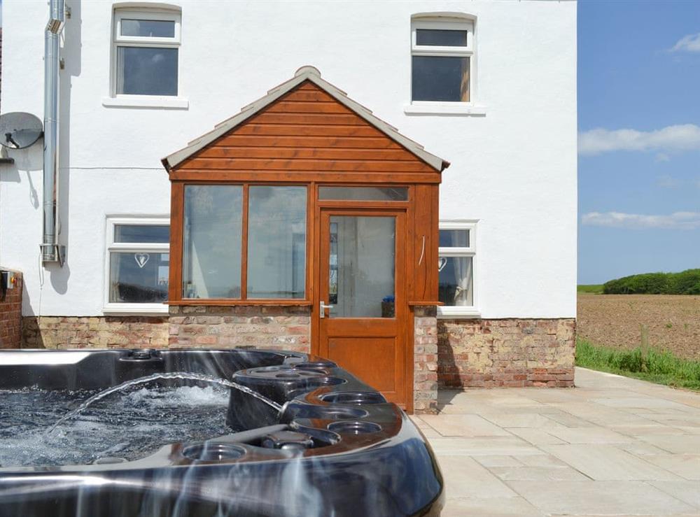 Luxurious hot tub on the patio at Granary Cottage in Bempton, near Bridlington, North Humberside
