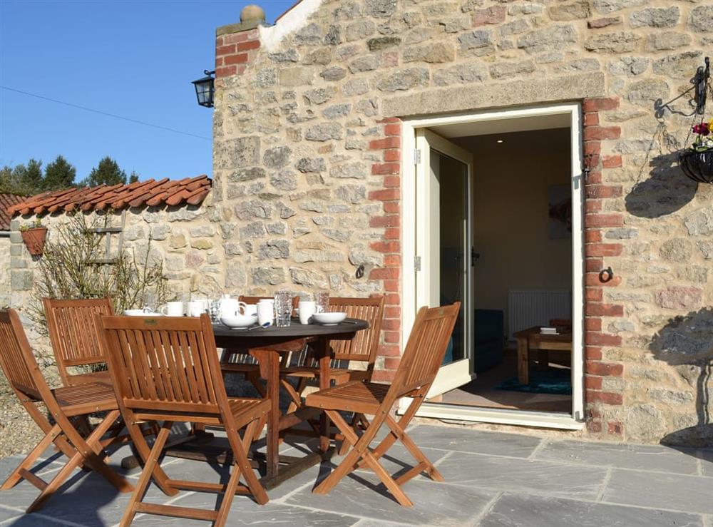 Paved patio with outdoor furniture at Grange Cottage in Harome, near Helmsley, North Yorkshire