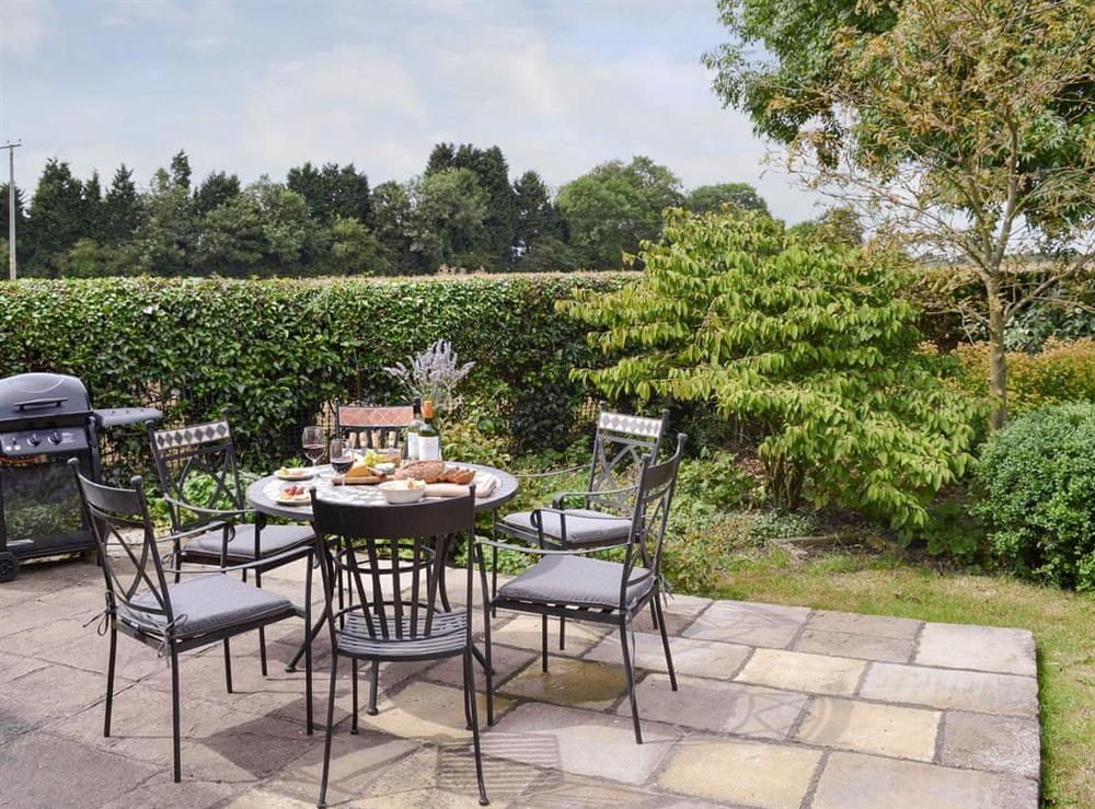 Patio area and BBQ within well-maintained garden at Portington Lodge, 