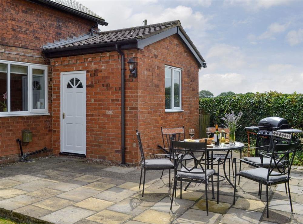 Paved patio with outdoor furniture and BBQ at Portington Lodge, 
