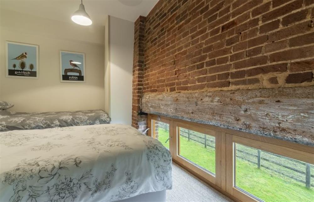 First floor: Bedroom two has exposed brick and low level windows at Great Barn, Toftrees near Fakenham
