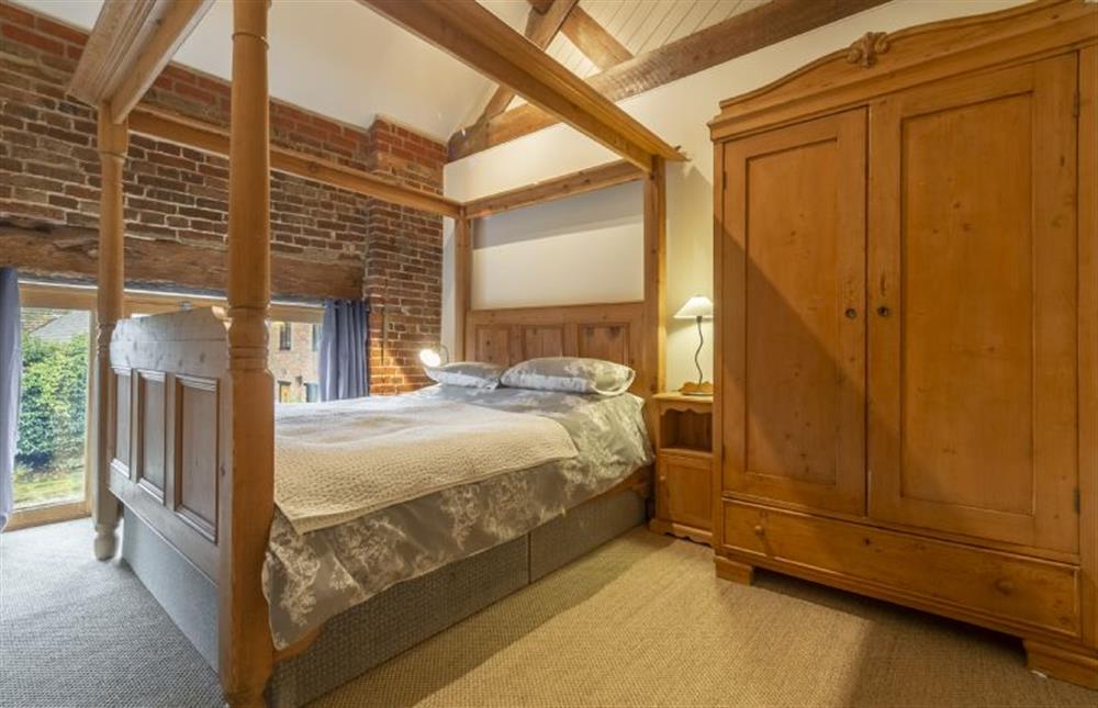 First floor: Master bedroom has four poster bed at Great Barn, Toftrees near Fakenham