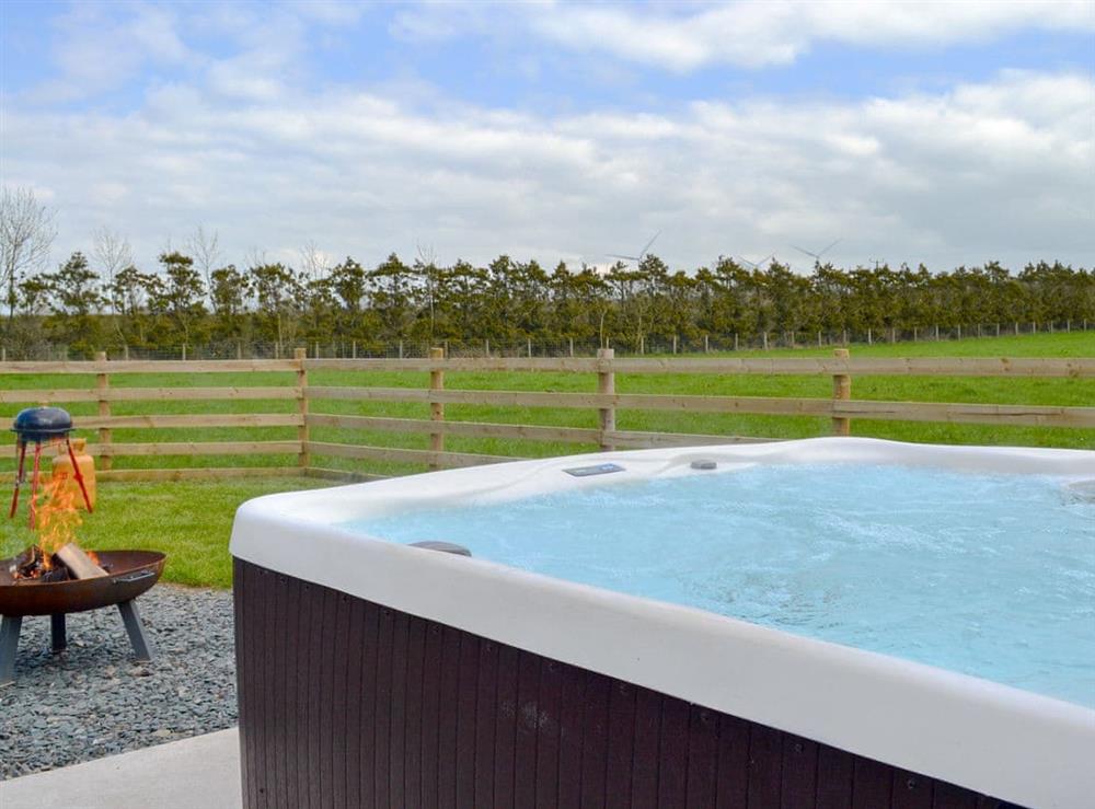 Relaxing private hot tub with countryside views and fire pit at Greengill Farm Shepherds Hut, 