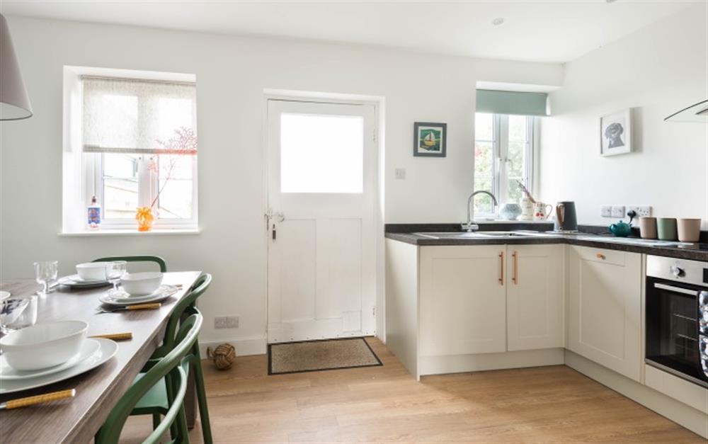 Open plan kitchen and dining area with door to rear garden at Greenhill Cottage in East Allington