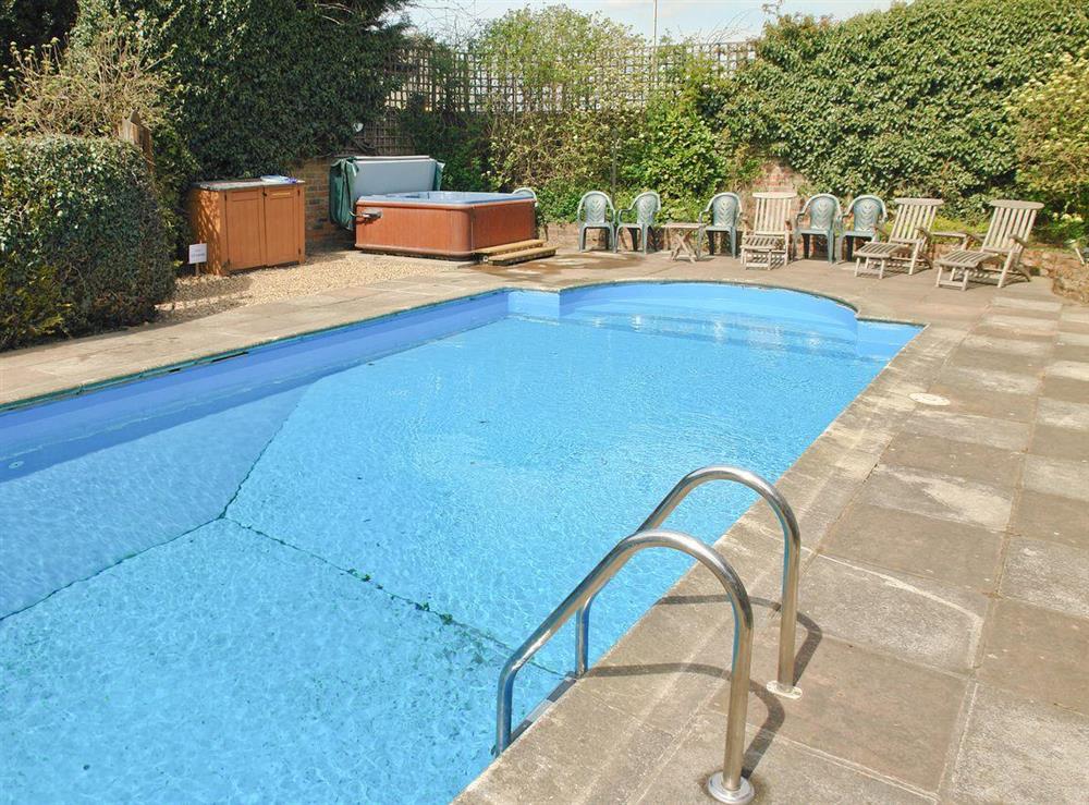 Large outdoor solar panel heated swimming pool with Hot-tub and poolside seating at Greenlands Farmhouse in Barmby Moor, York., North Yorkshire