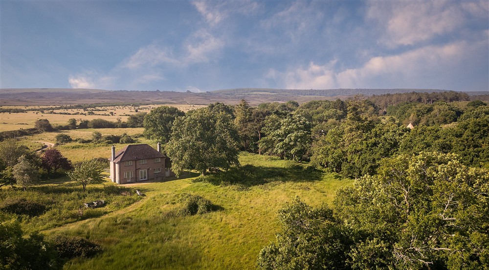 An aerial view of Greenlands, looking inland to fields, woodland and hills, Dorset