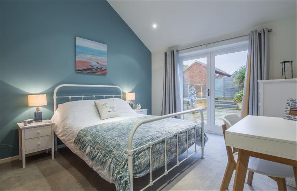 Ground floor: Master bedroom with french doors to the garden at Greyseals, Brancaster near Kings Lynn