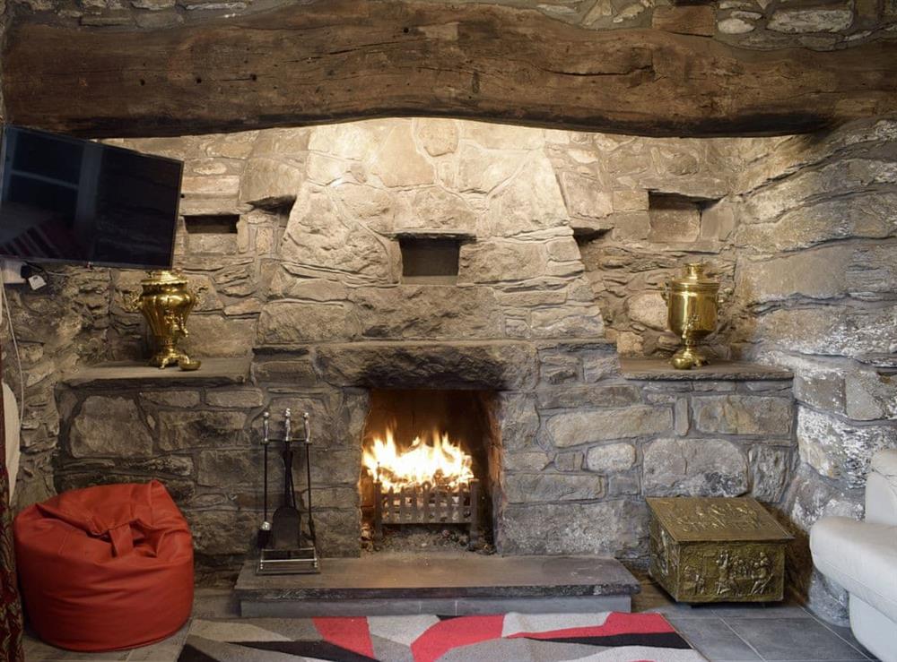 Outstanding stone fireplace within the living room at Groudd Hall Cottage in Cerrigydrudion, near Betws-y-Coed, Clwyd