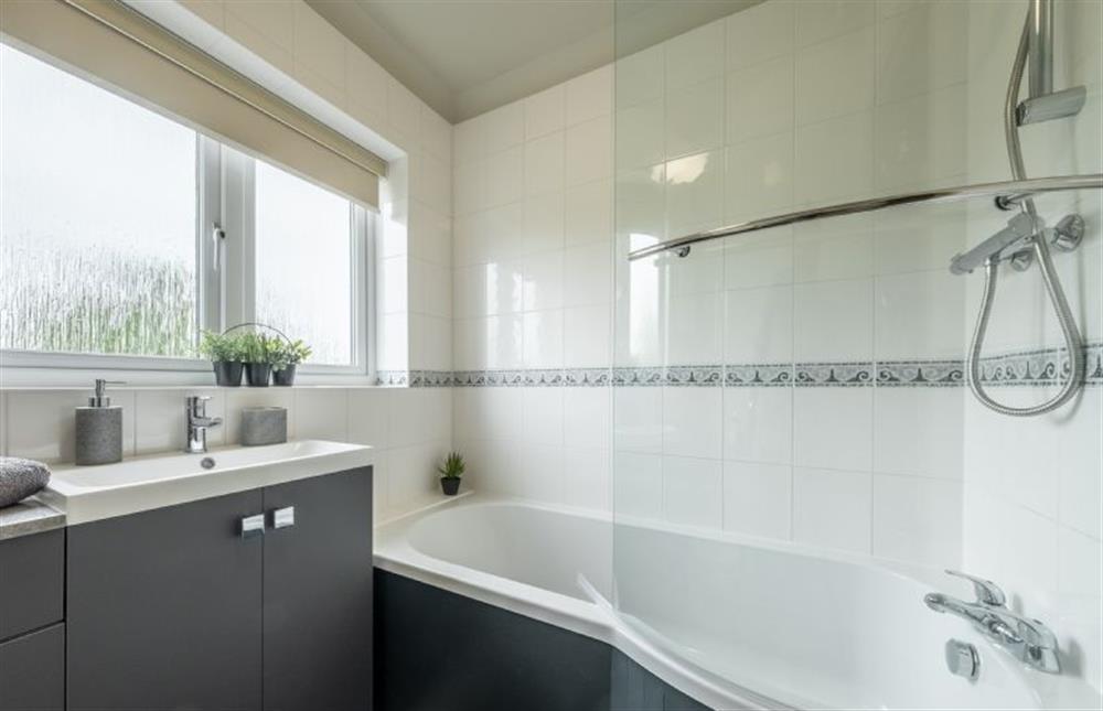 Family bathroom with bath and overhead shower at Gull Cottage, Holme-next-the-Sea