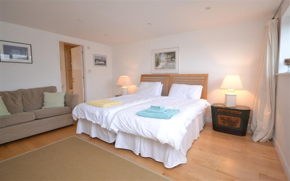 Bedroom 3 with 3ft twin beds, TV, door to patio and en suite bathroom at Gulls Nest in Salcombe