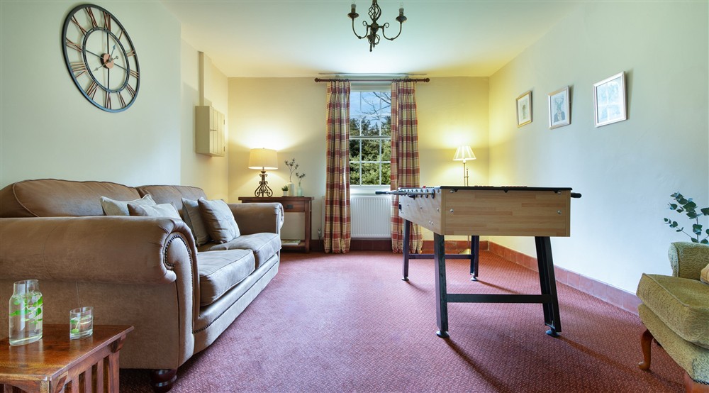 The games room with sofa and table football at Gunby Old Rectory in Skegness, Lincolnshire
