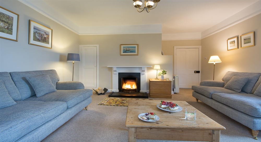 The sitting room with open fire at Gwendra Wartha in Truro, Cornwall