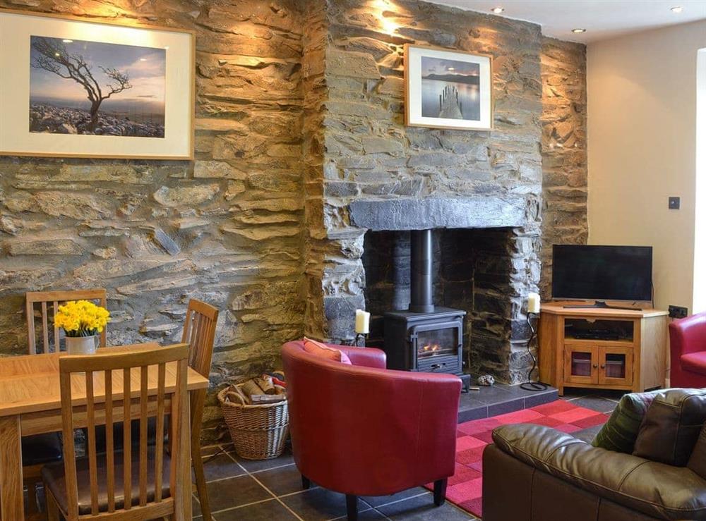 Living room with wood burner & dining area at Gwyrfai Cottage in Waunfawr, near Caernarfon, Gwynedd