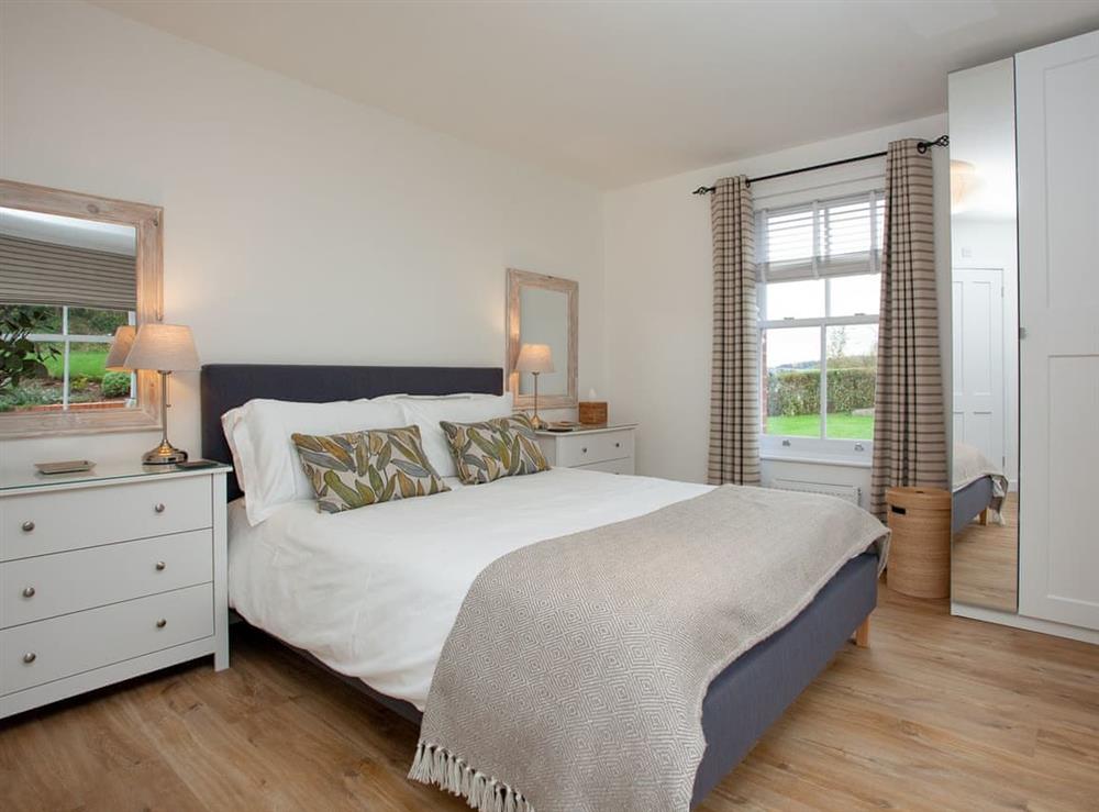 Bedroom on ground floor with king size bed and en suite at Haldon View in Lympstone, Devon