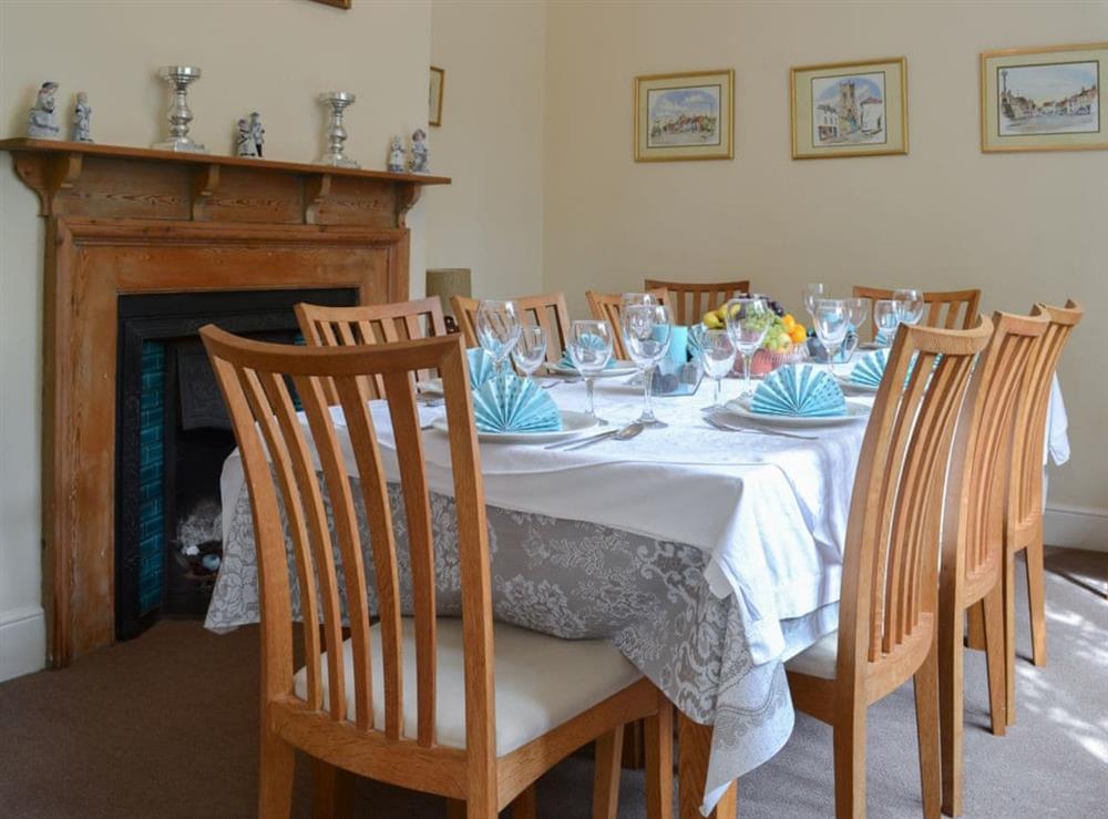 Elegant dining room with feature fireplace at Hall Cottage in Gresham, near Sheringham, Norfolk