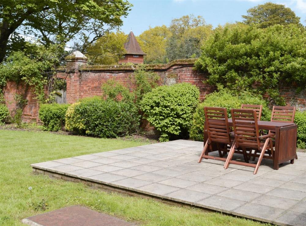 Paved and raised patio with wooden garden furniture at Hall Cottage in Gresham, near Sheringham, Norfolk
