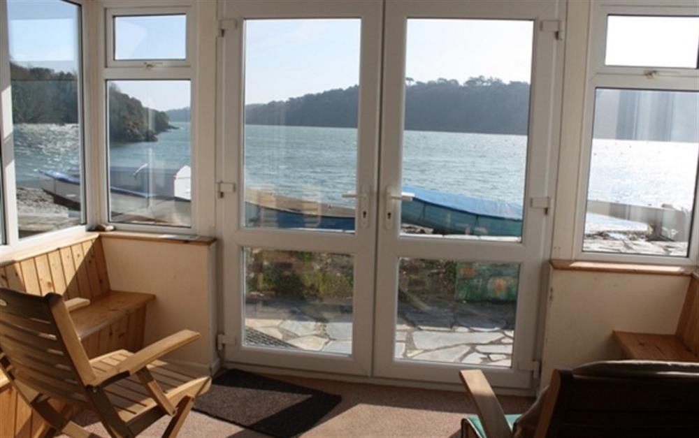 French doors open onto a patio with lovely views of the river. at Halliards in Helford Passage