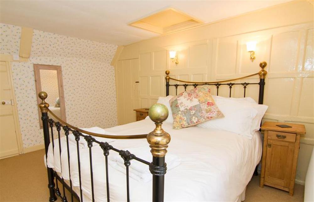 First floor:  Master bedroom with antique style brass and metal double bed at Hambledon, Cley-next-the-Sea near Holt