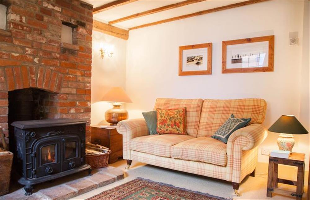 Ground floor:  Sitting area with comfy sofa and wood burning stove at Hambledon, Cley-next-the-Sea near Holt
