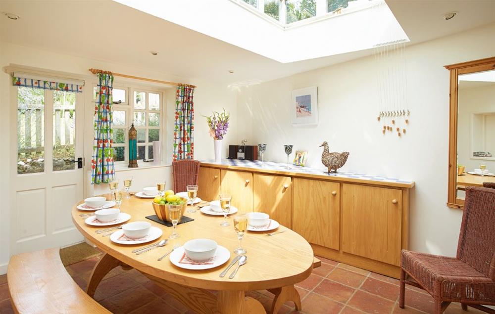 Dining room seating 8 guests with Fired Earth terracotta tiled floor and roof lantern at Hamilton House, Branscombe