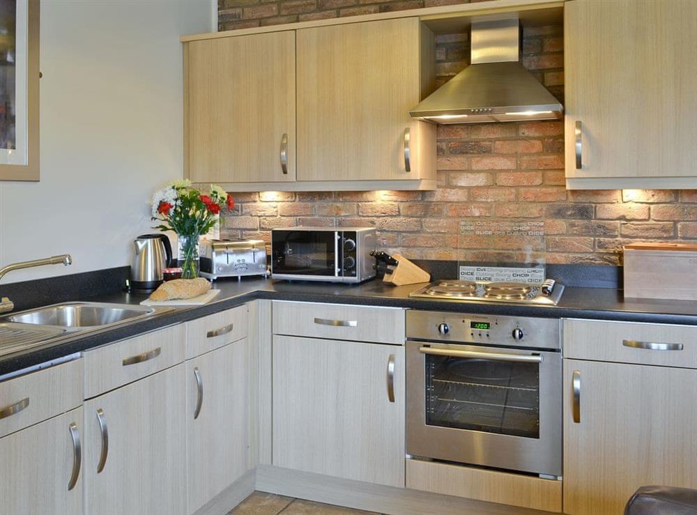 Well-equipped fitted kitchen area at Hampshire Cottage in Muston, Filey, North Yorkshire