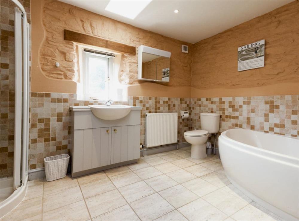 Great bathroom with corner bath at Hanger Mill Barn in Salcombe, Devon