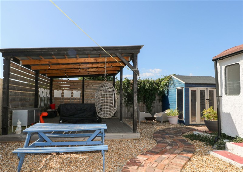 Enjoy a glass of wine on the patio at Harbour Road Quirky Beach Railway Carriages, Pagham