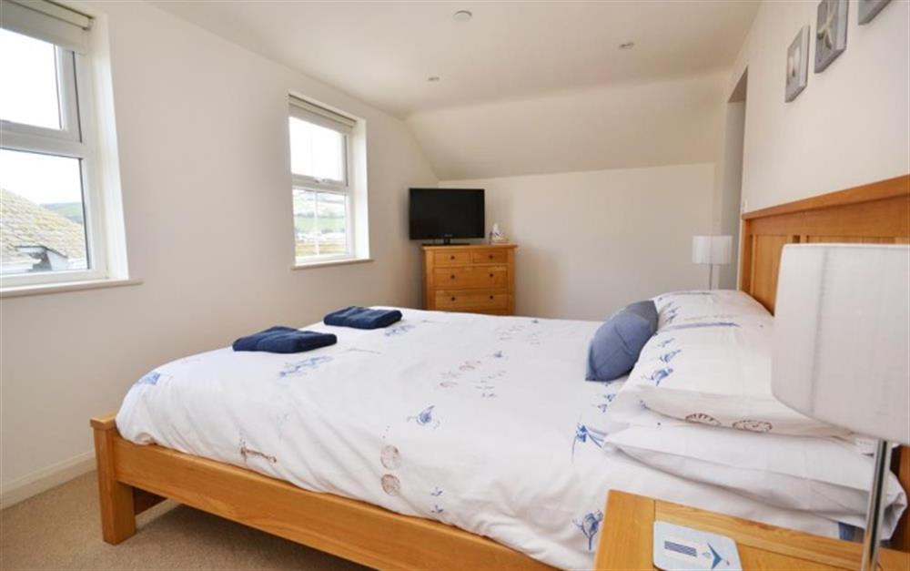 The master bedroom with TV, en suite shower room and estuary views at Harbour View in Salcombe